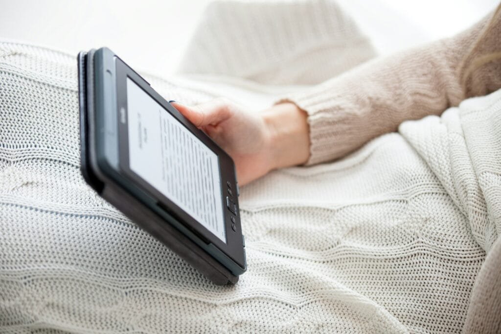 Digital ebook reader holding by woman at cozy home